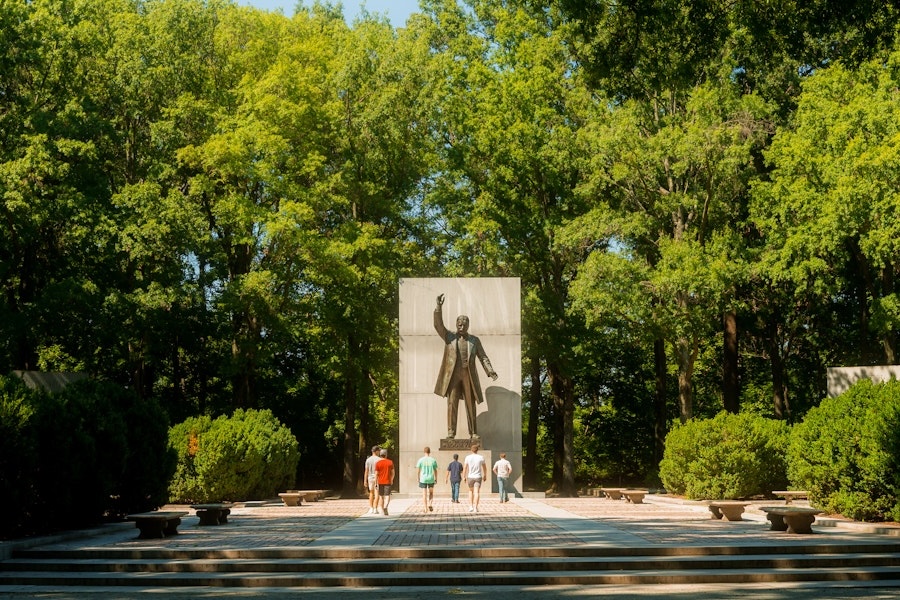 Visitors walk toward the large statue of Theodore Roosevelt at the memorial plaza on Theodore Roosevelt Island.