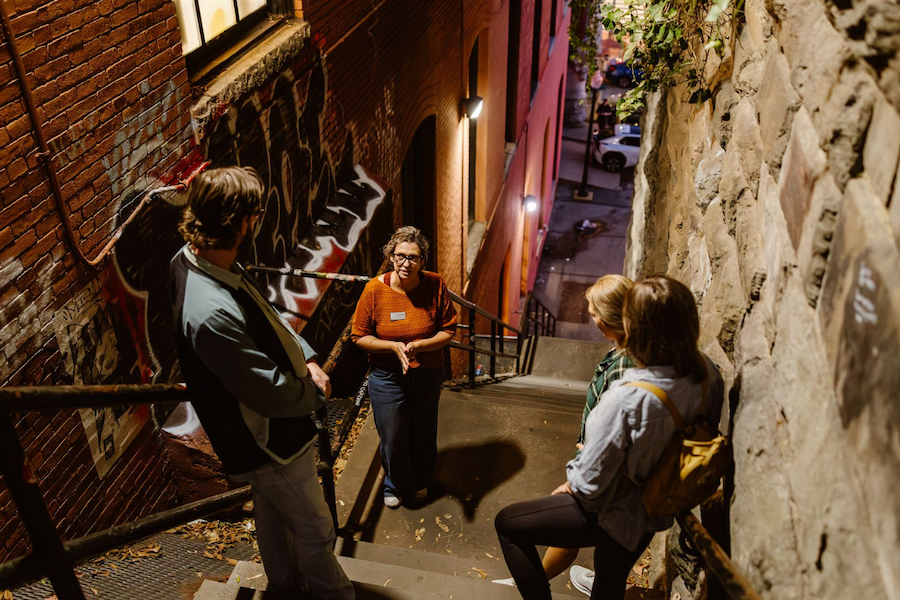 An evening tour group listens to a guide speak on Georgetown's famous Exorcist stairs.