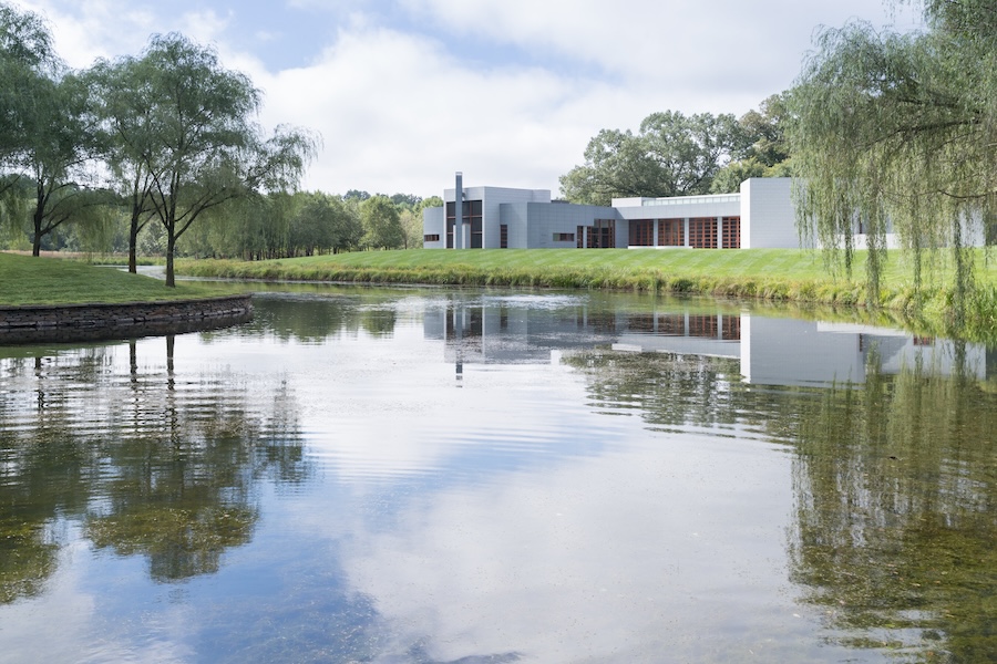 The Gallery at Glenstone Museum overlooks a tranquil pond surrounded by trees and grass.