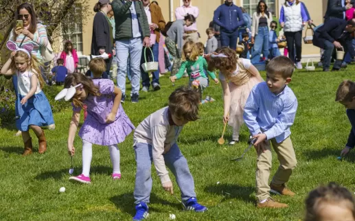 Children look for easter eggs on the lawn of Tudor Place. 
