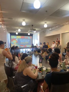 A large group gathers in a conference room for an Asian American and Pacific Islander Heritage Month lunch and learn at Destination DC.