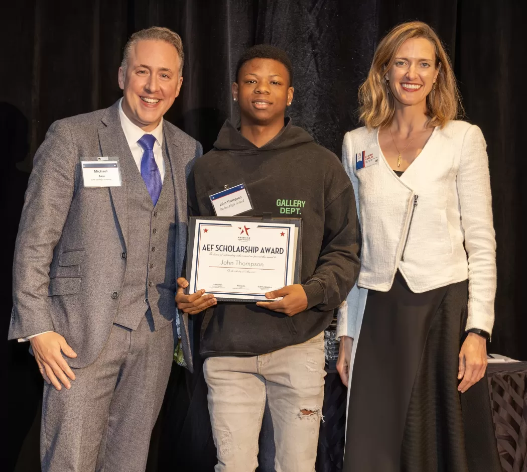 John Thompson holds his AEF scholarship in between Michael Akin and Claire Carlin